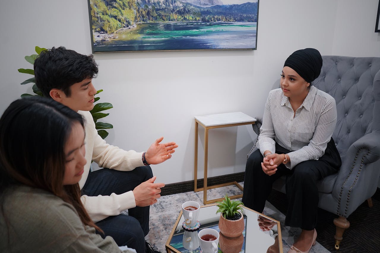 A couple in a therapy session discussing issues with a therapist in a modern office.