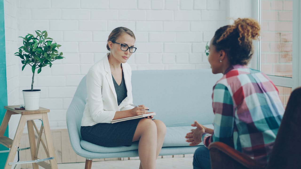 Therapist and client in a counseling session within a stylish modern office setting.